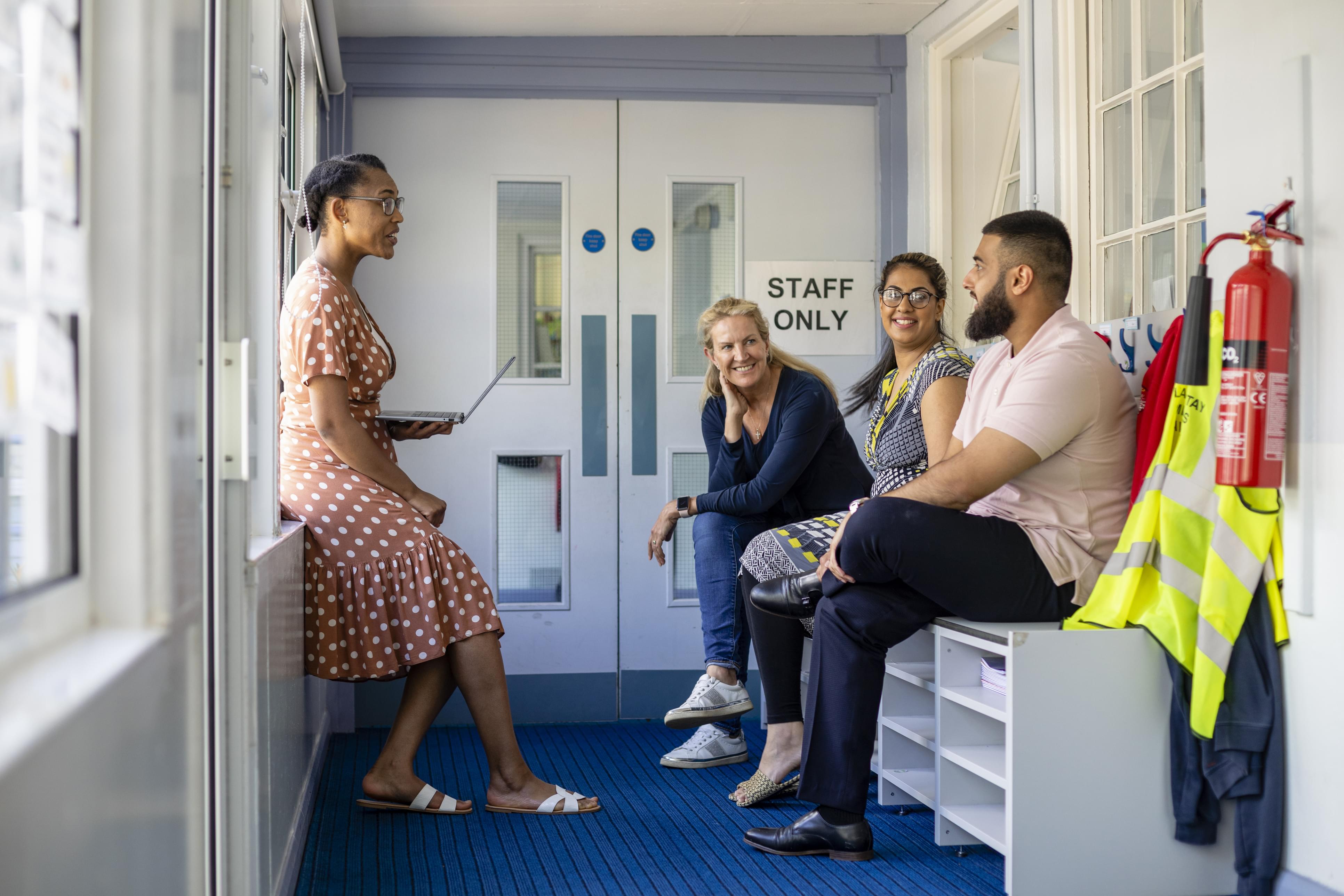 Teachers having an impromptu meeting in the hallway